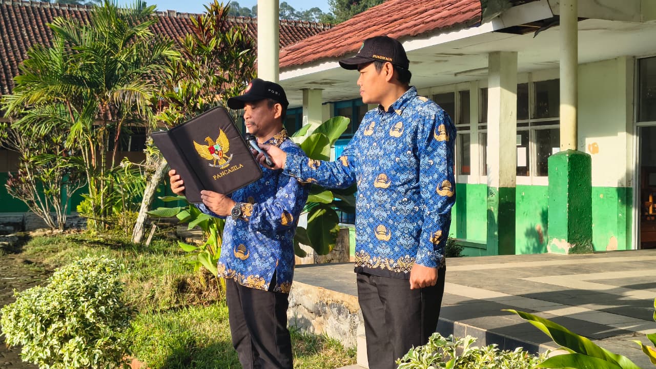 Guru SMPN 2 Kertasari mengikuti upacara peringatan Hari Pendidikan Nasional 2026 di lapangan sekolah.